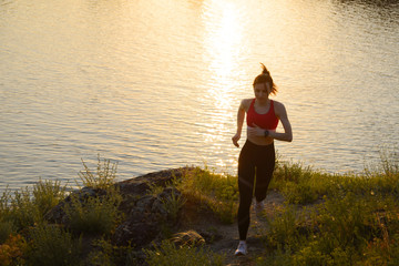 Fototapeta na wymiar Young Beautiful Woman Running on the Mountain Trail at Hot Summer Sunset. Sport and Active Lifestyle.