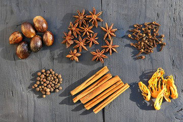 Collection of warming brown spices on wooden background