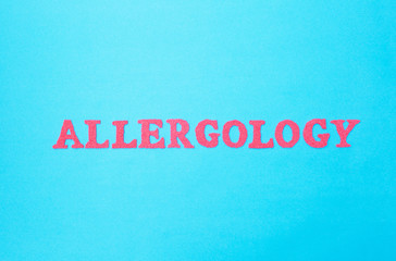 Fototapeta na wymiar Inscription allergology in red letters on a blue background, section of the medicine. Science studying human allergens, concept of human allergic reactions, background