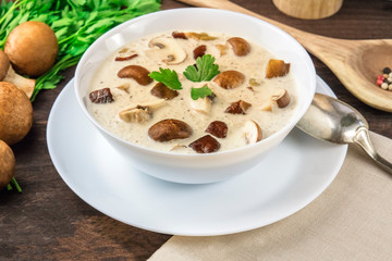 Mushroom soup with champignons and pepper on a dark rustic wooden background, selective focus