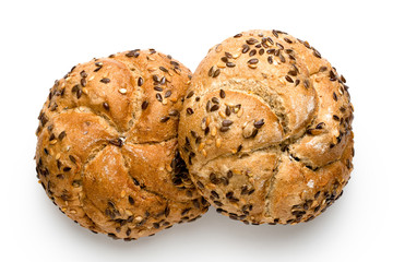 Two traditional whole wheat kaiser rolls with linseeds and sesame seeds isolated on white. Top view.