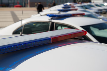 Police lights. Blue and red sirens on the roof of police car while policemen patrol the city © Igor Gromoff
