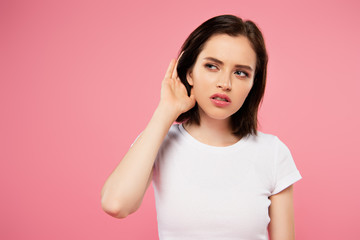 beautiful focused girl listening isolated on pink