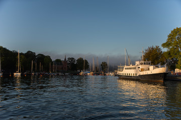 Naklejka premium Morning view over Stockholm inner harbour with boats, canoes, piers and islands an autumn day