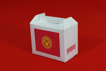 Kyrgyzstan flag on white box with barcode and the color of nation flag on red background. The concept of export trading from Kyrgyzstan.