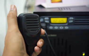 Hand holding ham radio speakers in the base station.