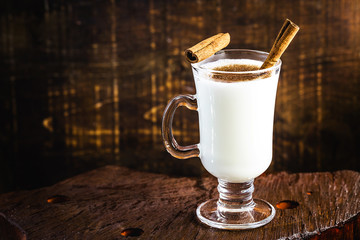 Christmas eggnog and typical winter drink for holiday festivities. Decorated with sugar cane, red and white. Space for text.