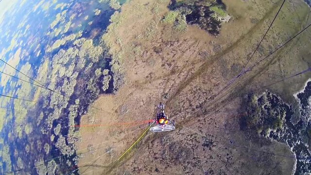 Top-mounted camera looking down on a paramotor pilot flying over the Florida Everglades
