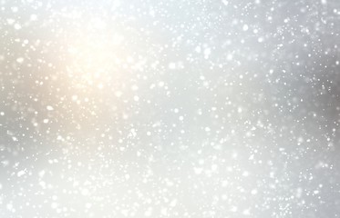 Fluffy snow falling on light silver outdoor blurry background. Winter sun shine fine. Lens flare. New year holiday natural abstract illustration.