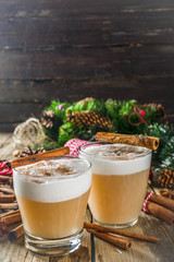Autumn winter hot toddy alcohol cocktail with spices, wooden background with christmas decorations. Christmas beverage idea recipe, copy space