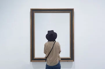 Fotobehang interior view of a lonely girl or tourist looking at blank canvas at a museum or gallery. © Alessandro