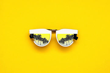 Naklejka premium White glasses with palm trees on a bright yellow background.