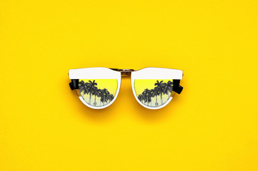 White glasses with palm trees on a bright yellow background.