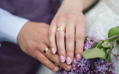 wedding rings on hands of bride and groom