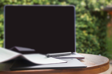 Modern laptop computer on wooden table in home garden