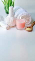 Obraz na płótnie Canvas Spa treatments set with spoon of salt, herbal compressing ball, candles and towel on white background.