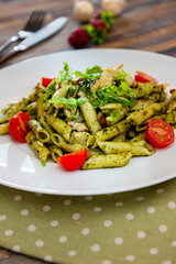 Pasta with pesto sauce and nuts on a the table