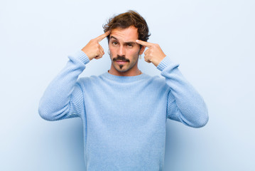 young handsome man with a serious and concentrated look, brainstorming and thinking about a...