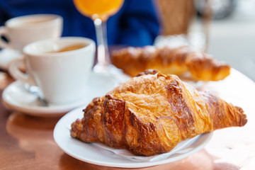 Breakfast with coffee and croissants on table