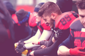 american football player holding the injured shoulder