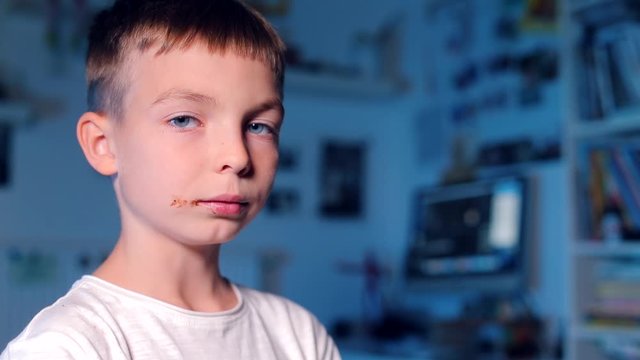 the boy eats chocolate, then shows the chocolate tongue