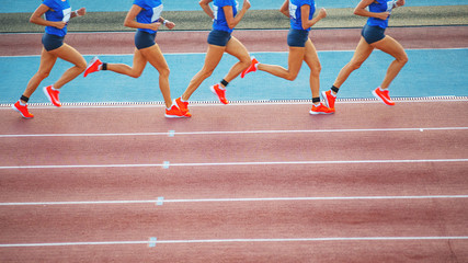 Female athlete runs on the athletic track. Running movement phases concept. - obrazy, fototapety, plakaty