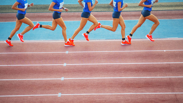 Female athlete runs on the athletic track. Running movement phases concept.