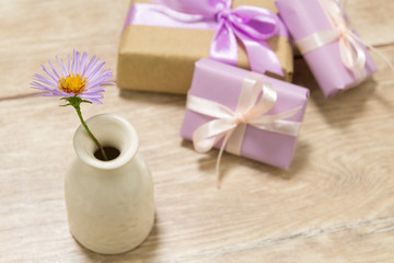 Gift boxes for Mother's Day. Flowers in a vase. Wooden table. The atmosphere of warmth and comfort