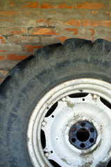 Fototapeta na wymiar ruota di trattore appoggiata al muro