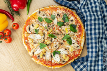 Italian, homemade Hawaiian pizza with chicken and pineapple on a wooden table. Top view food with copy space. Flat lay