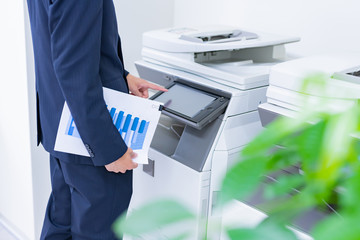 ビジネスシーン　コピー機を使うビジネスマン