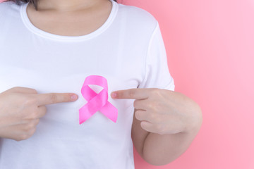 Healthcare, medicine and breast cancer awareness concept. Closeup on woman chest with pink breast cancer awareness ribbon.