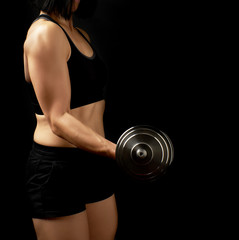 young woman of Caucasian appearance holds steel type-setting dumbbells in her hands