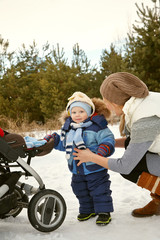 happy mother and baby in winter. family outdoors. cheerful mommy with her child.