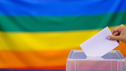 Hand holding ballot paper for election vote concept. elections, The hand of woman putting her vote...