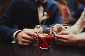The bride and groom drink tea at the time of the wedding photo shoot. No face. Cups of tea for bride and groom at wedding day. Loving couple in a cafe. hot tea for lovers