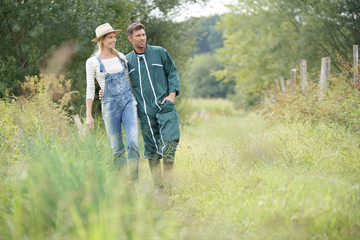 Fototapeta na wymiar Couple of farmers walking in field
