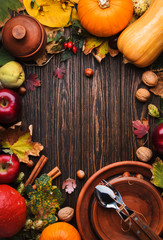 Fototapeta na wymiar Thanksgiving dinner place setting. Autumn fruit, pumpkins, nuts, fallen leaves with plate and cutlery. Thanksgiving autumn background