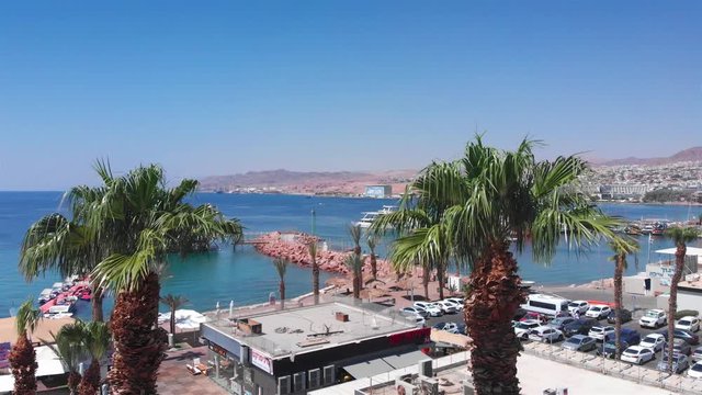 Palm tree and marina with sea and desert mountains aerial views Drone footage over Palm tree and marina with sea and desert mountains aerial views