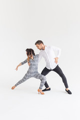 Young couple dancing latin dance bachata, merengue, salsa, kizomba. Two elegance pose over white background with copy space