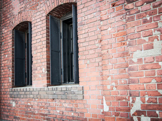 Fototapeta na wymiar Two window on a red brick wall.