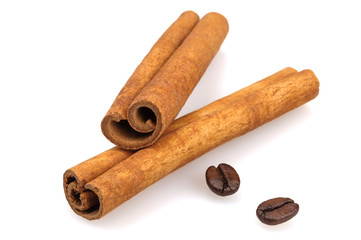 Cinnamon sticks and coffee grains on a white background.
