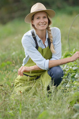 Naklejka na ściany i meble Portrait of farmer woman in strawberry field