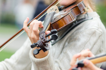 hands of a street musician girl with violin close up