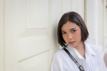 Portrait of a beautiful woman alone standing in front of the wall