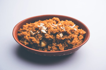 Wheat Laapsi/Lapsi/Shira/Halwa is an Indian sweet dish made of broken wheat or Daliya pieces and ghee along with nuts, raisins and dried fruits. It's a healthy food. served in a bowl, selective focus