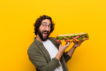young crazy bearded man with a giant sandwich.