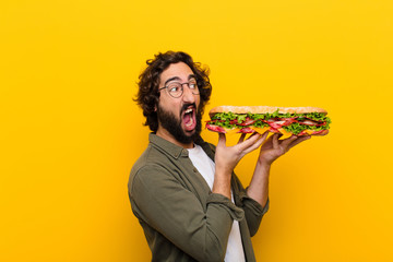 young crazy bearded man with a giant sandwich.