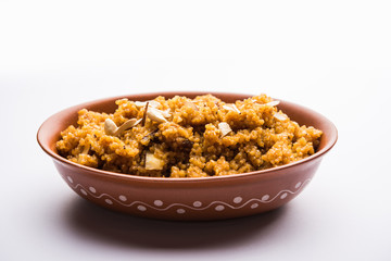 Wheat Laapsi/Lapsi/Shira/Halwa is an Indian sweet dish made of broken wheat or Daliya pieces and ghee along with nuts, raisins and dried fruits. It's a healthy food. served in a bowl, selective focus