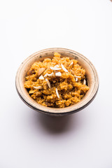 Wheat Laapsi/Lapsi/Shira/Halwa is an Indian sweet dish made of broken wheat or Daliya pieces and ghee along with nuts, raisins and dried fruits. It's a healthy food. served in a bowl, selective focus